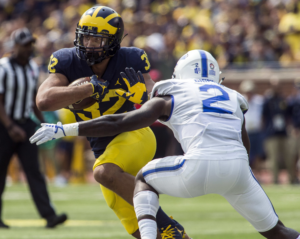 Ty Isaac of Michigan attempts to run past Marquis Griffin of Air Force during the second quarter of Michigan's 29-13 victory Saturday. The seventh-ranked Wolverines improved to 3-0 and dropped the Falcons to 1-1.