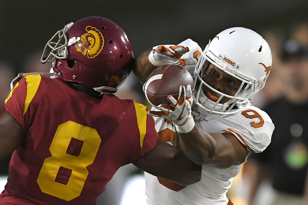 Texas wide receiver Collin Johnson catches a pass as USC cornerback Iman Marshall defends.