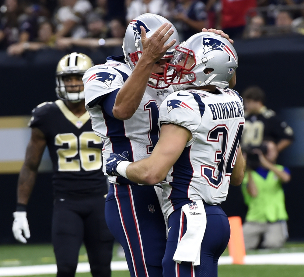 New England Patriots running back Rex Burkhead, right, celebrates his touchdown with quarterback Tom Brady in the first half of the Patriots' 36-20 win over the New Orleans Saints on Sunday in
