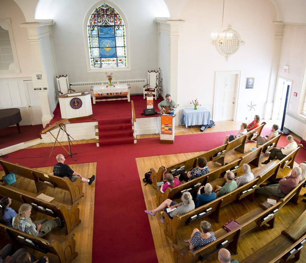 The congregation at the Universalist Unitarian Church in Waterville listens as Stan Davis plays his guitar and sings during a service Sunday.