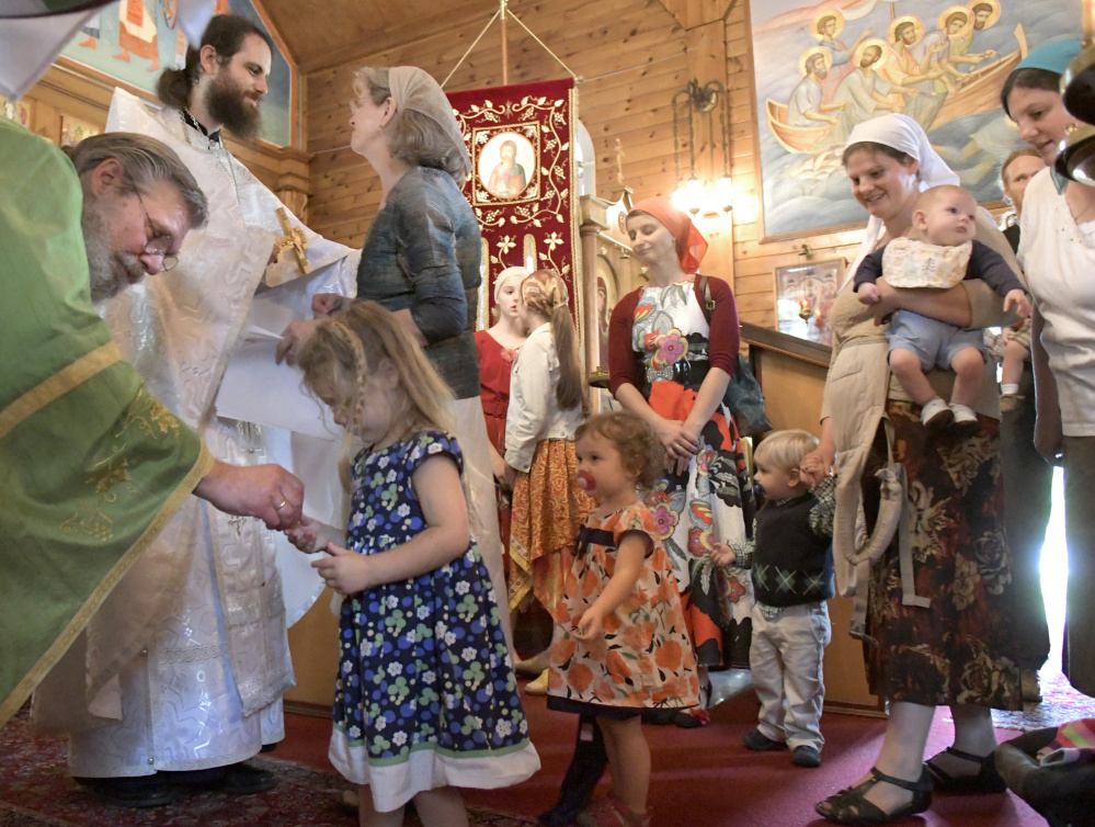 Nathan Williams, second from left, is greeted Sunday by his mother, Cindy, after his elevation to the priesthood in the Russian Orthodox Church during services at the St. Alexander Nevsky Church in Richmond. 