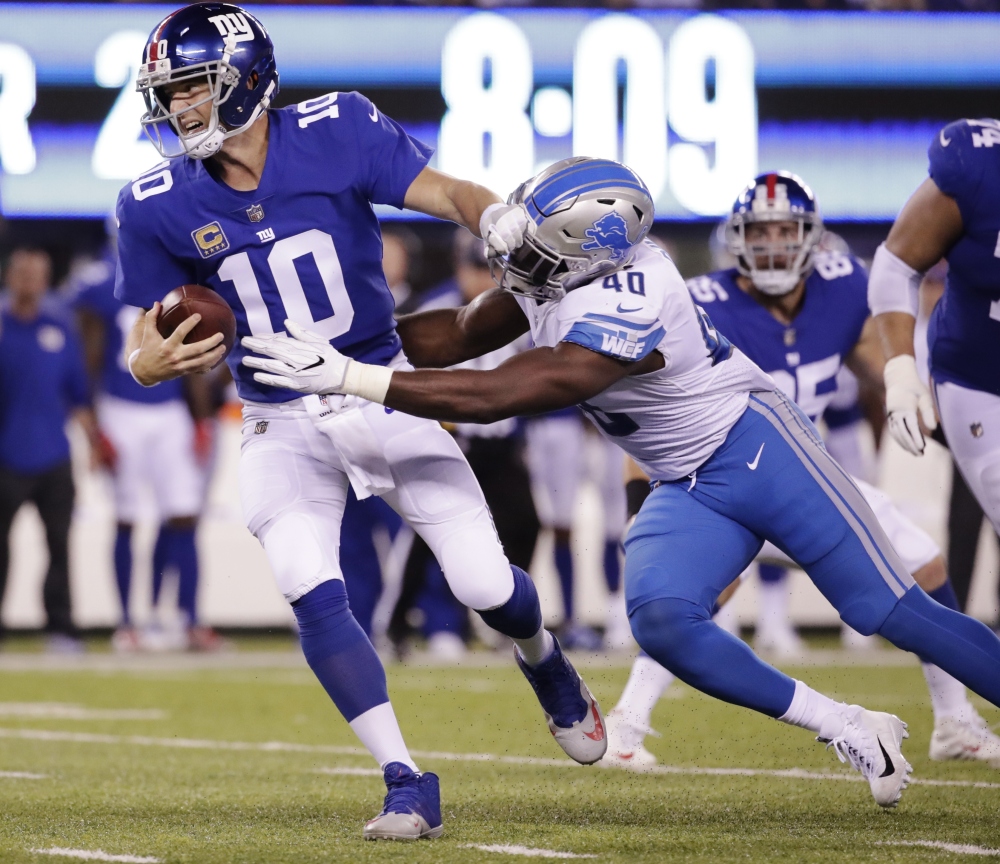 Giants quarterback Eli Manning is sacked by the Lions' Jarrad Davis in the first half.