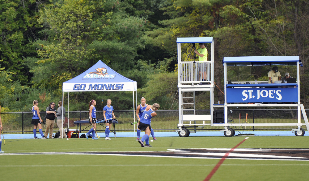 The St. Joseph's field hockey team warms up at the school's new sports complex. The facility has produced immediate results: The Monks are 5-0-1 on the artificial turf in men's and women's soccer, and field hockey.