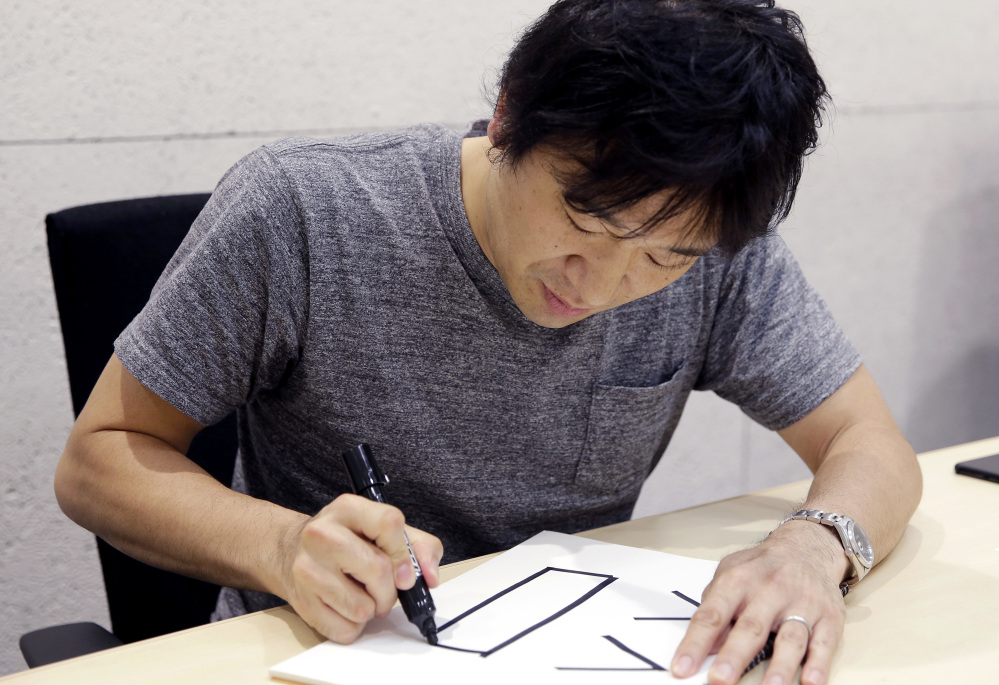 Django Co., Ltd. Director Shigetaka Kurita writes a pictograph during an interview at his office in Tokyo.