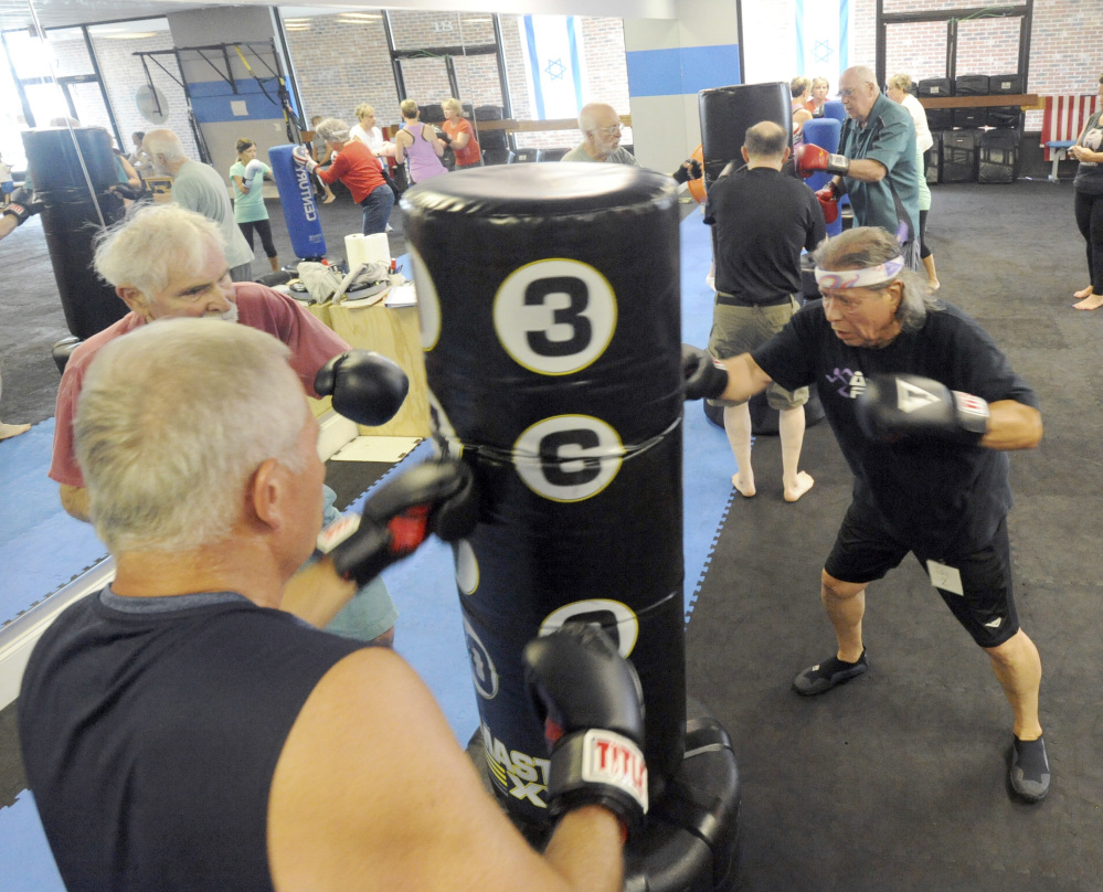 Jay Zavala of Falmouth, Mass., right, Ralph Tomasian of West Barnstable, left, and Charlie Tempinski of Marstons Mills work out in a Rock Steady class in Hyannis. The boxing program is designed to counter symptoms of Parkinson's disease.
