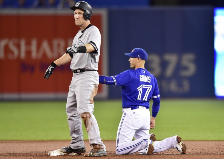 Blue Jays shortstop Ryan Goins holds the tag on Todd Frazier after Frazier hit a double in the third inning at Toronto on Friday. One play later, Goins got Frazier out on a hidden ball trick.