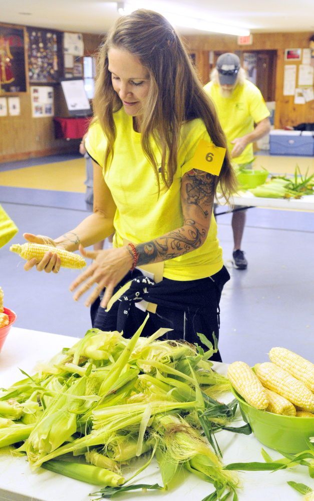 Tina Keech shucks corn in the first event of the Central Maine Amazing Race fundraiser Saturday at the Lions Club in Manchester.