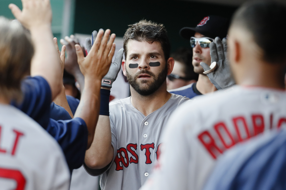 Boston's Mitch Moreland celebrates in the dugout after hitting a three-run homer off Cincinnati's Robert Stephenson in the sixth inning of Saturday's game in Cincinnati. The Red Sox won, 5-0.