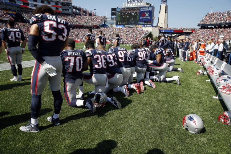 Several New England Patriots players kneel during the national anthem before Sunday's game.