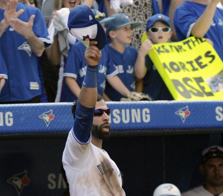 Toronto's Jose Bautista tips his hat to the crowd after leaving the game in the ninth inning of the Blue Jays' 9-4 win over New York on Sunday in Toronto.