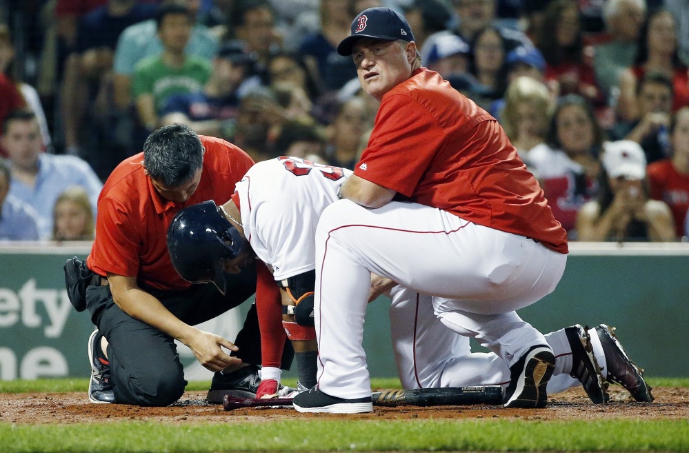 Red Sox manager John Farrell, right, and a trainer tend to Eduardo Nunez in the third inning Monday night. Nunez aggravated a right knee injury and was removed from the game after finishing his at-bat.
