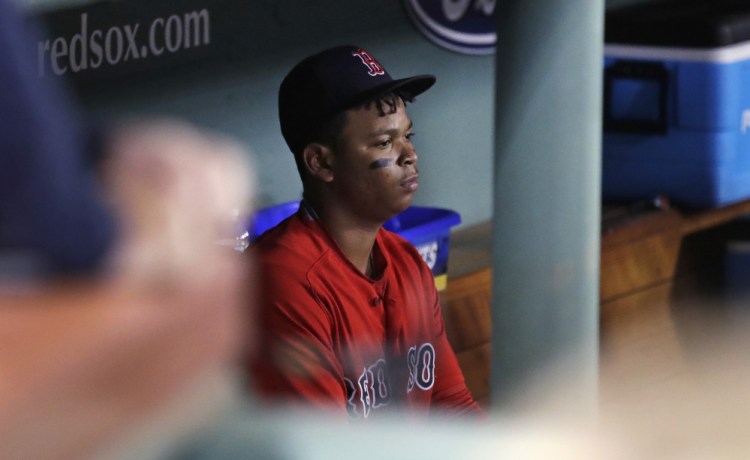 Boston's Rafael Devers sits in the dugout after grounding out to end the game Friday, leaving the Red Sox needing one more win or a Yankees loss to win the AL East.