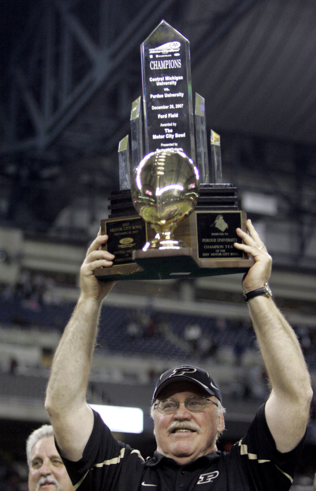 FILE - In this Dec. 26, 2007, file phoot, Purdue head football coach Joe Tiller holds up the winning trophy after defeating Central Michigan 51-48 to win the Motor City Bowl NCAA college football game in Detroit.  Tiller, the winningest football coach in Purdue history, died Saturday, Sept. 30, 2017, in Buffalo, Wyo., the school said. He was 74. (Associated Press/Carlos Osorio)