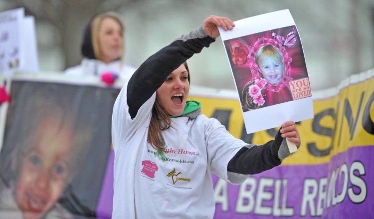 Trista Reynolds, mother of missing toddler Ayla Reynolds, holds a picture of her daughter in January 2014 at the Colby Circle and College Avenue intersection in Waterville during a rally. Trista Reynolds is seeking a formal court declaration that Ayla is dead so a wrongful death lawsuit can be pursued against Ayla's father, Justin DiPietro.
