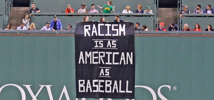 A banner is unfurled over the left field wall during the fourth inning of Wednesday night's game at Fenway Park.