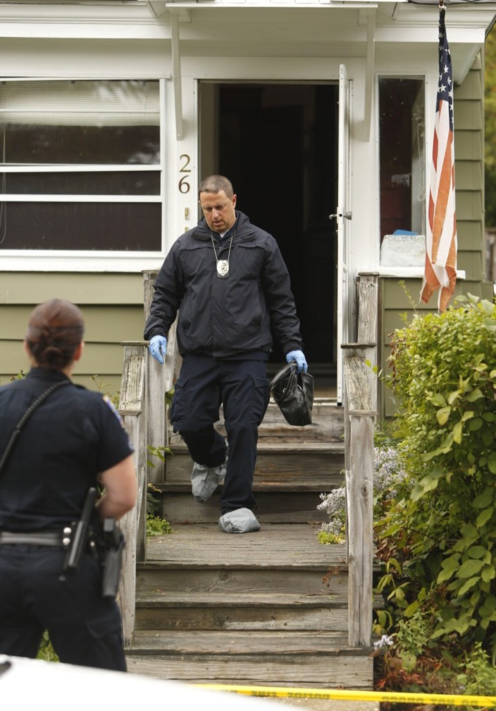 A police investigator exits the front door of 26 Nye St. in Saco.