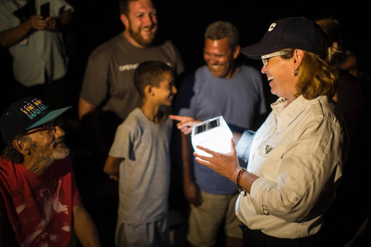 San Juan Mayor Carmen YulÌn Cruz distributes solar lamps in the city's La Perla neighborhood. Cruz issued emotional pleas Friday for the federal government to step up hurricane relief efforts in Puerto Rico.
