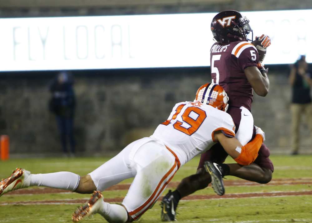 Virginia Tech receiver Cam Phillips hauls in a pass as Clemson safety Tanner Muse makes the stop.