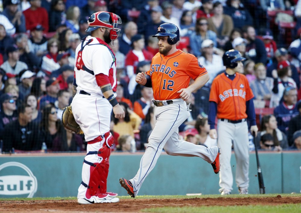 Houston's Max Stassi scores in front of Boston's Sandy Leon in the seventh inning when the Astros scored four times to beat the Red Sox 4-3 on Sunday in Boston.