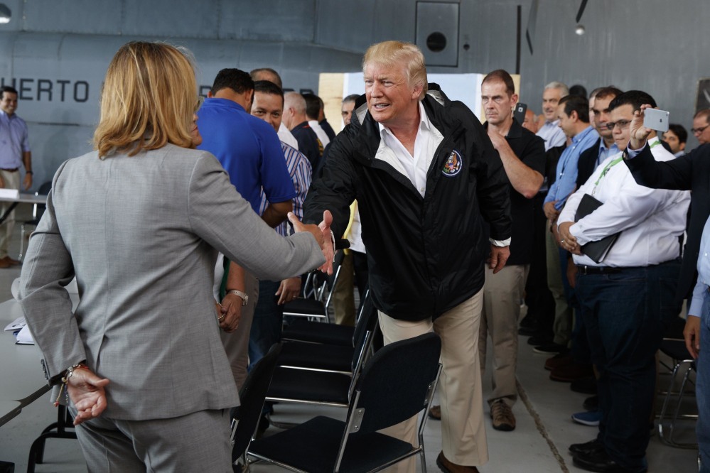 President Trump shakes hands with San Juan Mayor Carmen Yulin Cruz during a briefing on hurricane recovery efforts with first responders at Luis Muniz Air National Guard Base Tuesday in San Juan, Puerto Rico.