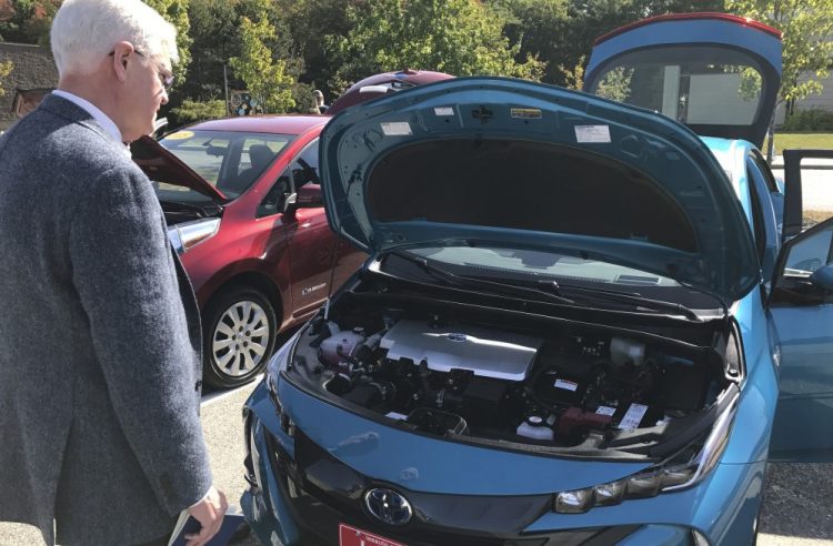 Steve McGrath, director of the governor's energy office, examines the engine on a Toyota Prius Prime on Wednesday, at a seminar in Brunswick on workplace charging stations for electric vehicles.