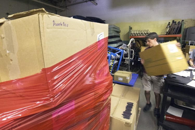 Doug Beahm, an intern for Partners for World Health, loads boxes of medical supplies onto a pallet.