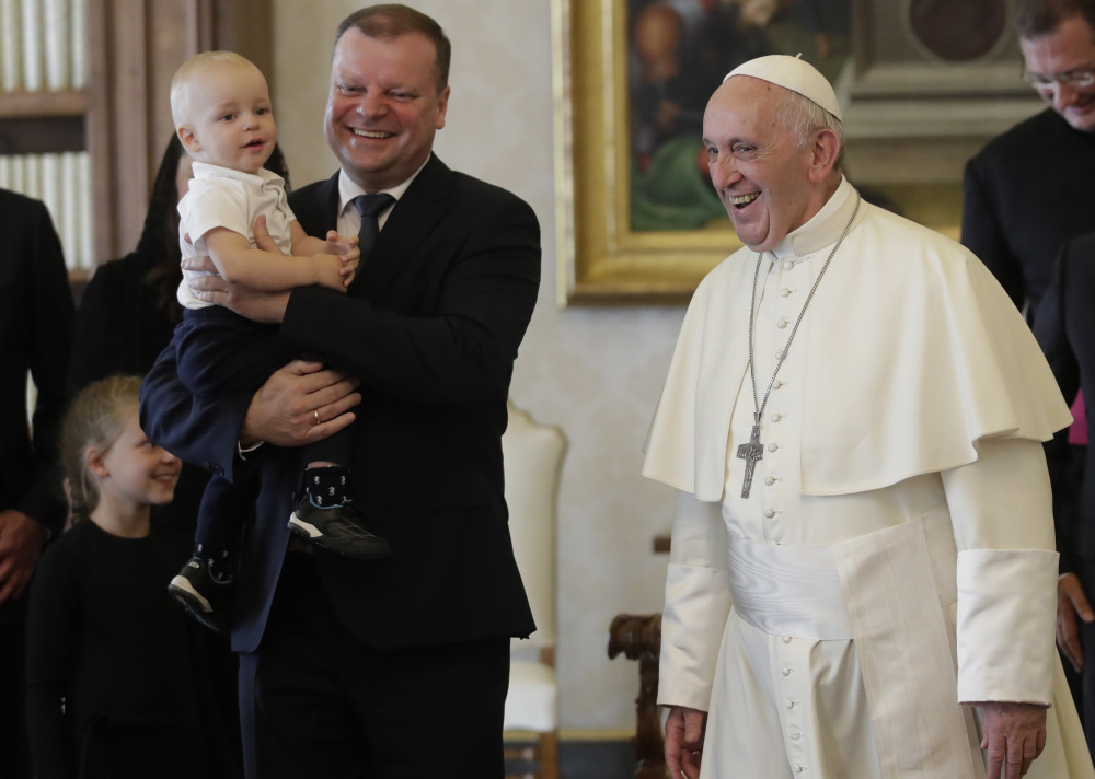 Pope Francis smiles with Prime Minister of Lithuania Saulius Skvernelis, carrying his son Tadas, at the end of their private audience at the Vatican on Friday.