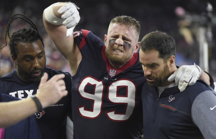 Texans defensive end J.J. Watt is helped off the field after he was injured Sunday night in Houston. Watt broke his left leg and will likely miss the rest of the season.