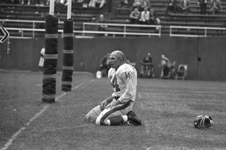 New York quarterback Y.A. Tittle squats on the field after being hit hard while passing during a game against the Steelers in Pittsburgh. Tittle, the Hall of Fame quarterback and 1963 NFL Most Valuable Player, has died. He was 90.