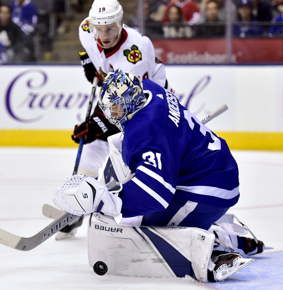 Maple Leafs goalie Frederik Andersen makes a save as Chicago's Jonathan Toews chases the rebound Monday night in Toronto. The Leafs won in overtime, 4-3.
