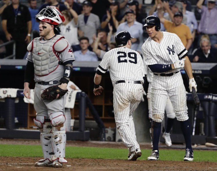 The Yankees' Aaron Judge, right, greets Todd Frazier after Frazier scored from third on a sacrifice fly by Brett Gardner in the fifth inning as New York stretches its lead to 6-3.