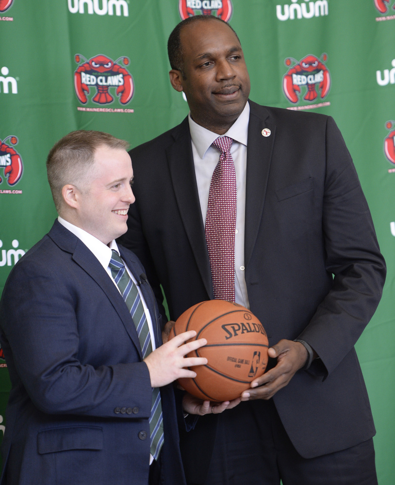 Brandon Bailey, left, the new coach of the Maine Red Claws, poses for photographs Thursday with Dajuan Eubanks, the team president. Bailey was the Boston Celtics' video coordinator since 2011.