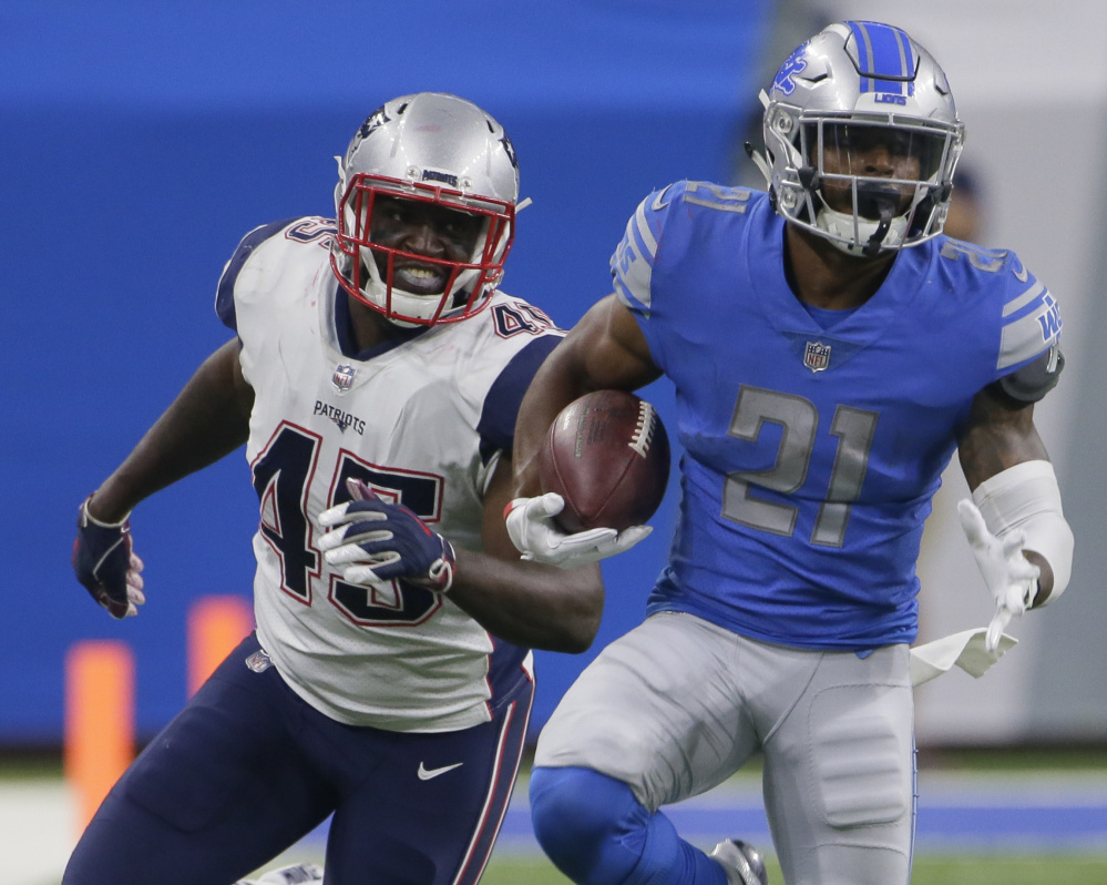 Detroit running back Ameer Abdullah looks for yardage during a preseason game as he is pursued by New England linebacker David Harris.