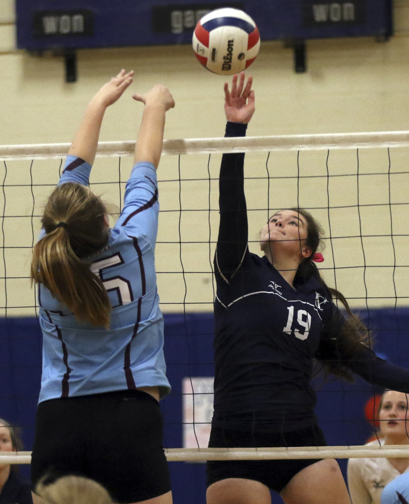 Ceanne Lyon, right, of Yarmouth tips the ball over the net as Windham's Meghan Harmon defends during a volleyball match Thursday in Yarmouth. Yarmouth, ranked No. 2 in Class B, defeated the Class A Eagles in three sets to improve to 12-1.