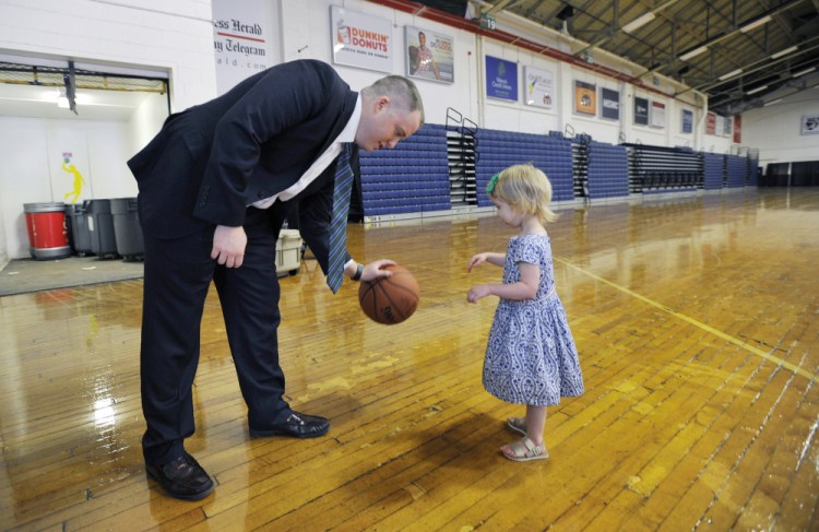 Brandon Bailey plays with his daughter Kary, 3, at the Portland Expo on Thursday prior to a news conference where Bailey was announced as the Red Claws' new head coach. Staff photo by Shawn Patrick Ouellette