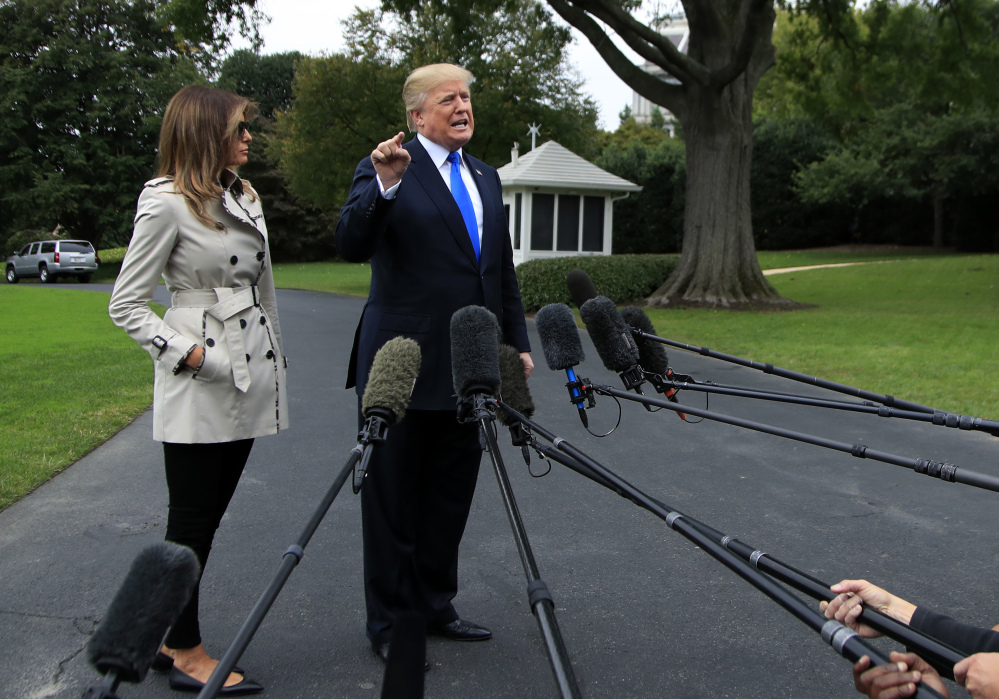 President Trump, with first lady Melania Trump, speaks to reporters on the South Lawn of the White House on Friday. Trump said on Twitter, "ObamaCare is a broken mess."