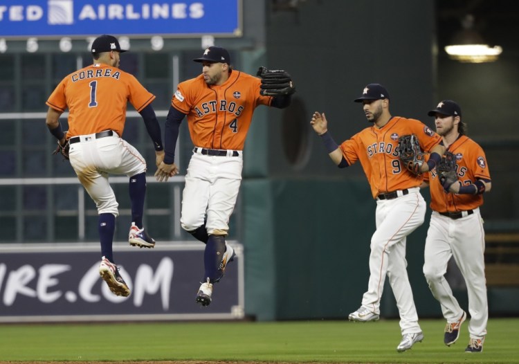 Houston Astros' Carlos Correa and George Springer celebrate after Game 1 of the American League Championship Series on Friday in Houston. The Astros won 2-1 to take a 1-0 lead in the series.