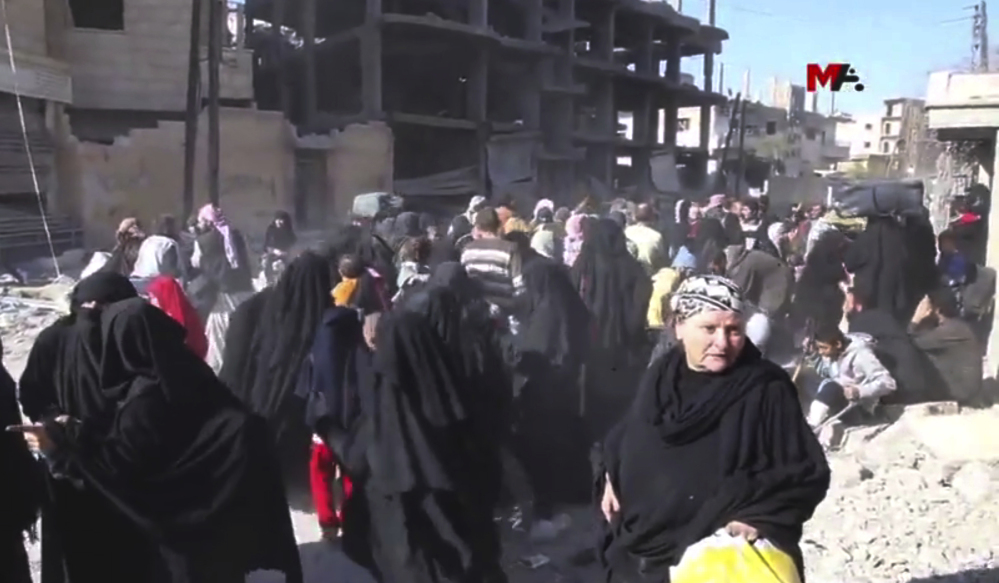 This frame grab from a video provided Friday by Turkey-based Kurdish Mezopotamya agency media outlet shows Syrian civilians who fled from the areas that are still controlled by the Islamic State militants in Raqqa, Syria. 