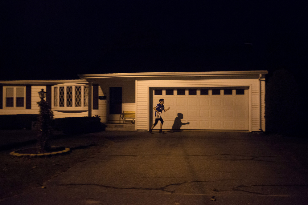 Donna Wall jogs between houses on her newspaper delivery route, an overnight job that pays about $7,000 a year. The single mother, 60, takes only Christmas off. She took the post to help her care for her three adult autistic children, two of whom are nonverbal. Nov. 7's ballot measure on Medicaid expansion hits home for Wall, who lost her MaineCare eligibility once her two boys, Christopher and Brandon, turned 18. "I still take care of them just as much, if not more, than I did two years ago and when they were little," she said. Staff photo by Brianna Soukup