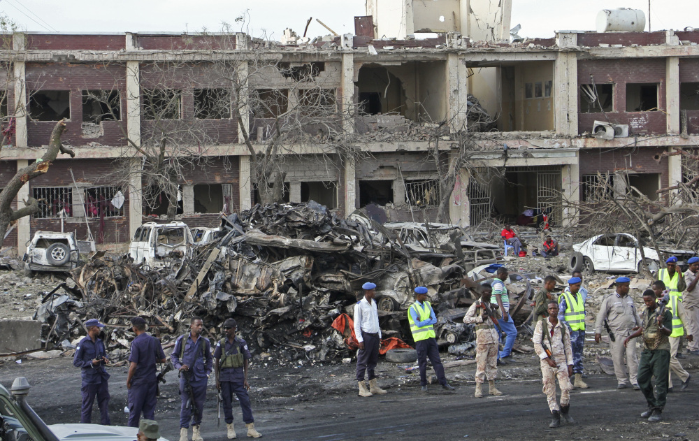 Somali security forces and others gather and search for bodies near destroyed buildings as hospitals struggled to cope with the high number of casualties.