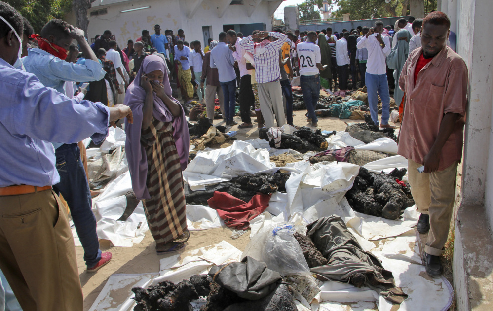 A Somali woman reacts as she stands by the remains of victims of Saturday's blast in Mogadishu on Sunday. The death toll from the most powerful bomb blast witnessed in Somalia's capital rose to at least 230 with more than 200 injured.