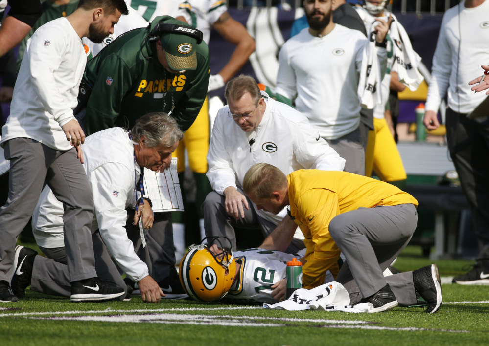 Packers quarterback Aaron Rodgers is checked by medical staff after being hit by Minnesota linebacker Anthony Barr in the first half Sunday in Minneapolis. The Packers later revealed that Rodgers has a broken collarbone and might have to miss the rest of the season.