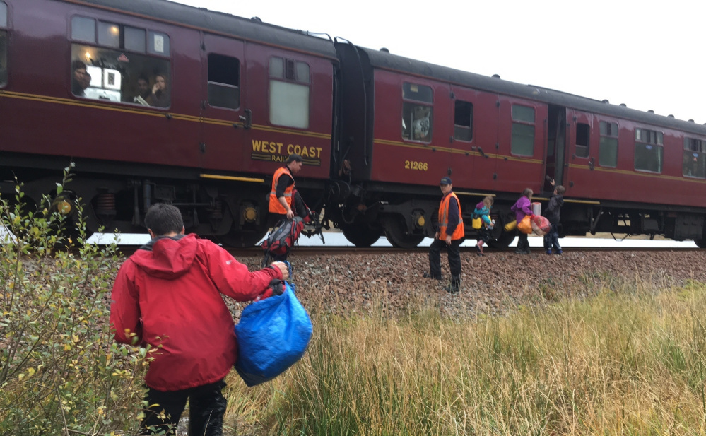 The Cluett kids run to the train that picked them up in the Scottish Highlands after the family canoe washed away. The train was known as Hogwarts Express in Harry Potter films.