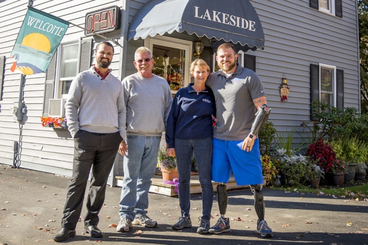 Zach Stewart, far left, and Army veteran Travis Mills, who lost his arms and legs in an explosion, are the new owners of Lakeside Motel & Cabins. They are joined by Mills' parents, Dennis and Cheri Mills, who will help maintain the motel and cabins in East Winthrop.