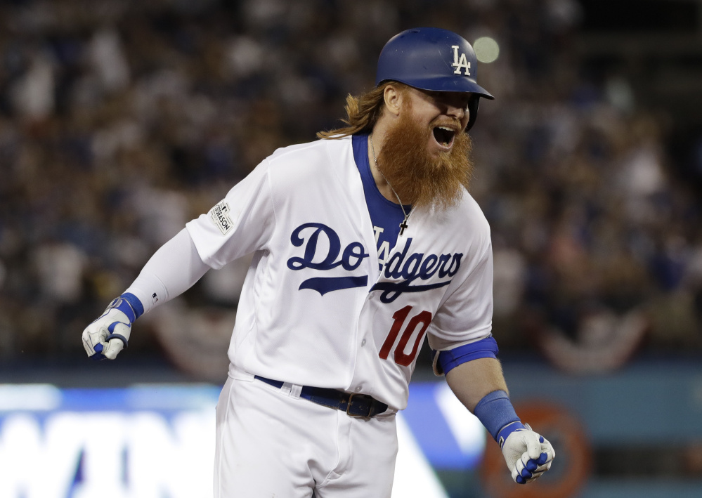 Justin Turner celebrates his game-winning three-run homer with two outs in the bottom of the ninth inning Sunday night, lifting the Dodgers to a 4-1 win over the Cubs in Game 2 of the National League Championship Series.