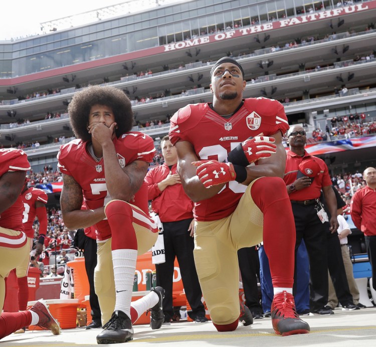 San Francisco quarterback Colin Kaepernick, and safety Eric Reid kneel during the national anthem before an NFL game against Dallas in 2016.  Kaepernick has filed a grievance with the league accusing teams of colluding to not hire him.