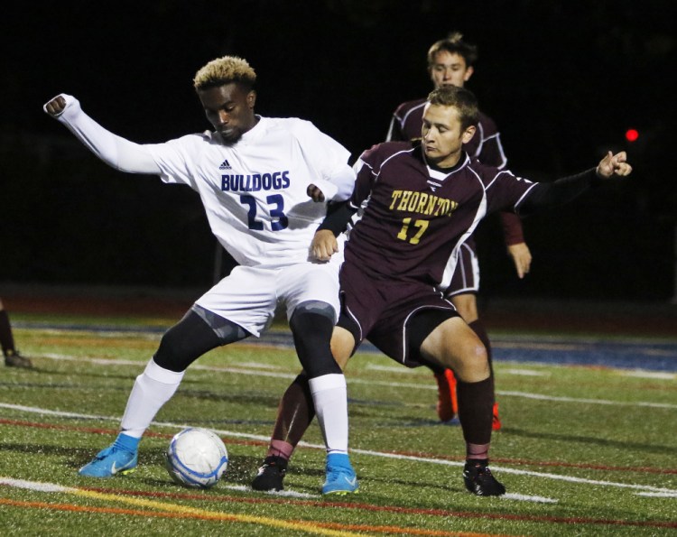 Pedro Fonseca of Portland tries to hold the ball against Thornton Academy's Jake Nason during their SMAA game Monday at Fitzpatrick Stadium. Portland won, 2-1, and will take a 10-3-1 record into the Class A South playoffs.