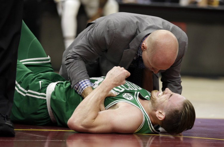 Gordon Hayward grimaces in pain as trainers come to his side on Tuesday in Cleveland. Just five minutes into his first game with Boston, the new star forward gruesomely broke his left ankle, an injury likely to end his season and drop the Celtics out of contention as a top team in the Eastern Conference.