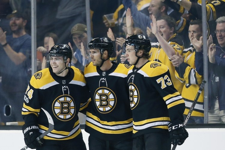 Boston's David Krejci, center, celebrates his goal with Jake DeBrusk, 74, and Charlie McAvoy in the first period Thursday night in Boston.