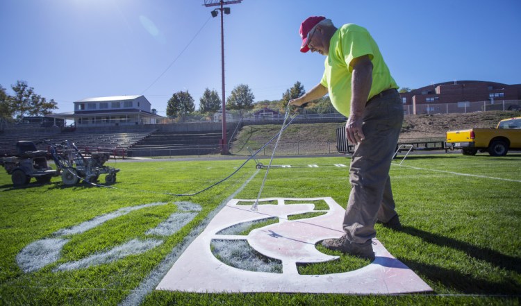 Bill Thyng of the Sanford Parks and Recreation Department paints the numbers at Cobb Stadium on Thursday in preparation for Sanford's football game Friday night against Thornton Academy. Barring a Sanford upset, it will be the last high school football game at the stadium.